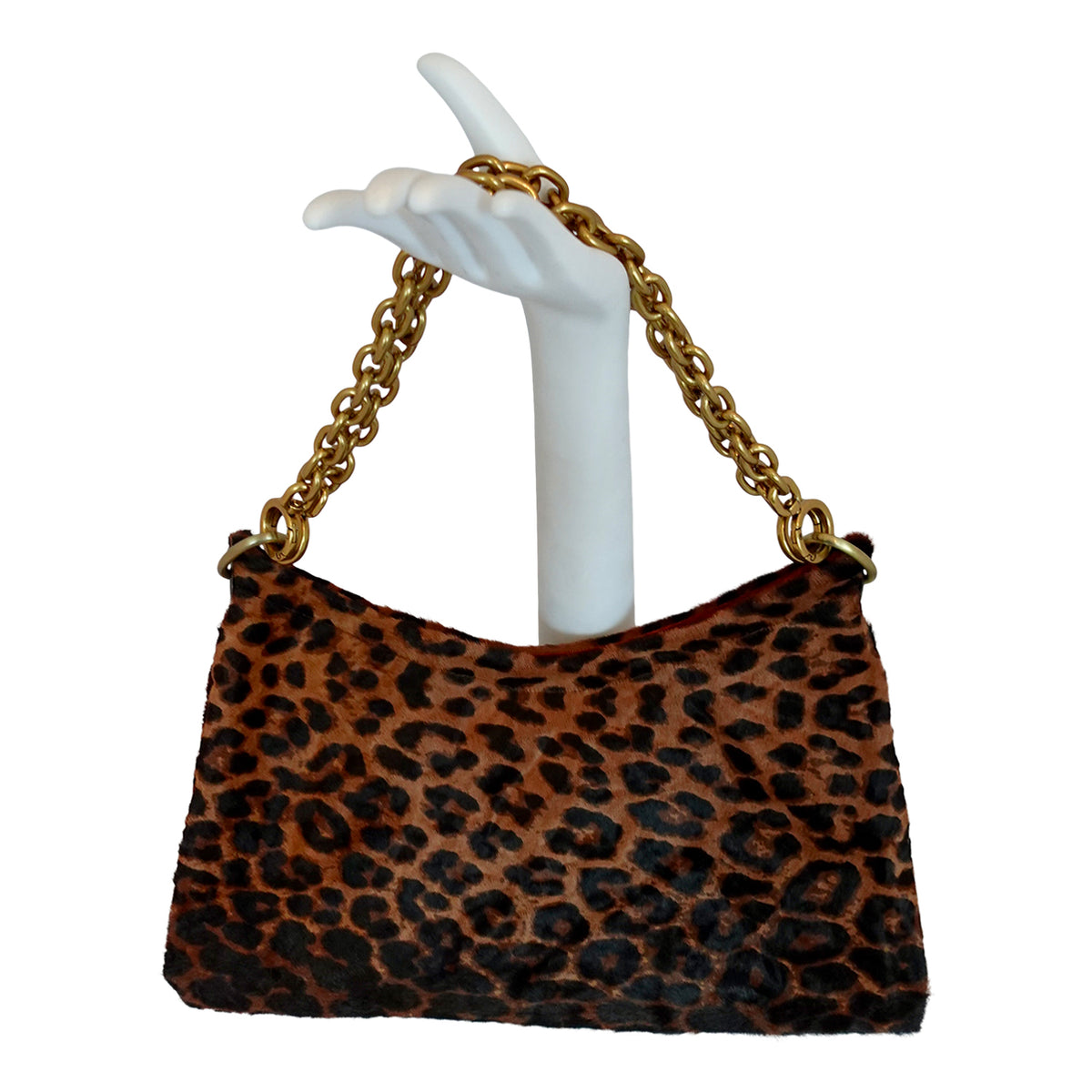 a hand holding a leopard print purse
