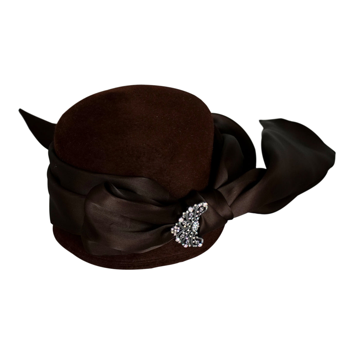 a brown hat with a ribbon and a brooch